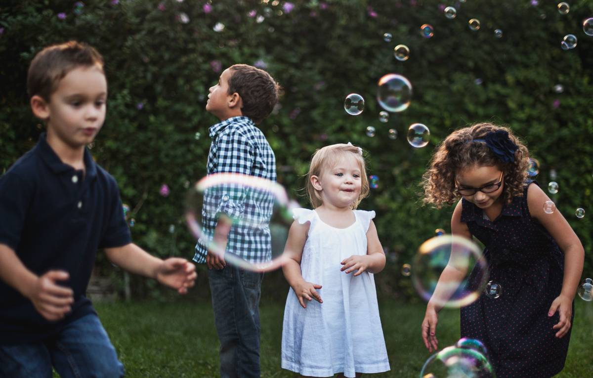 Children outside engage in play-based learning.