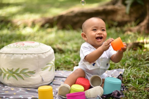 Infant plays with cups outside