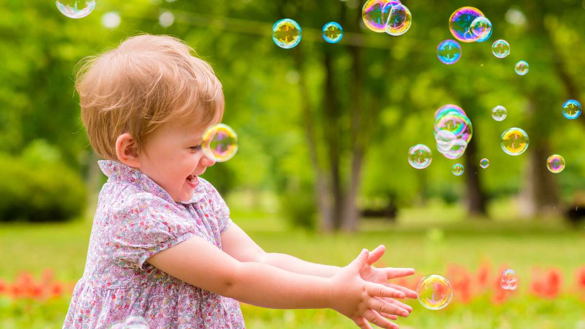 Baby girl playing with bubbles
